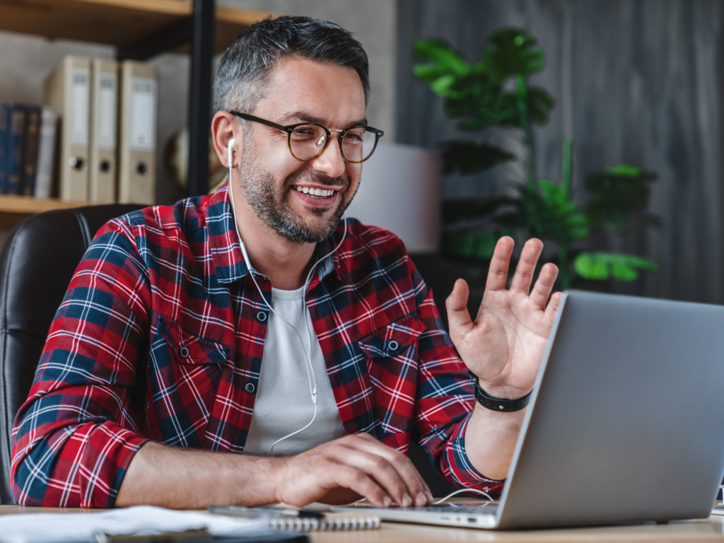 Man on zoom call discussing business with earbuds in