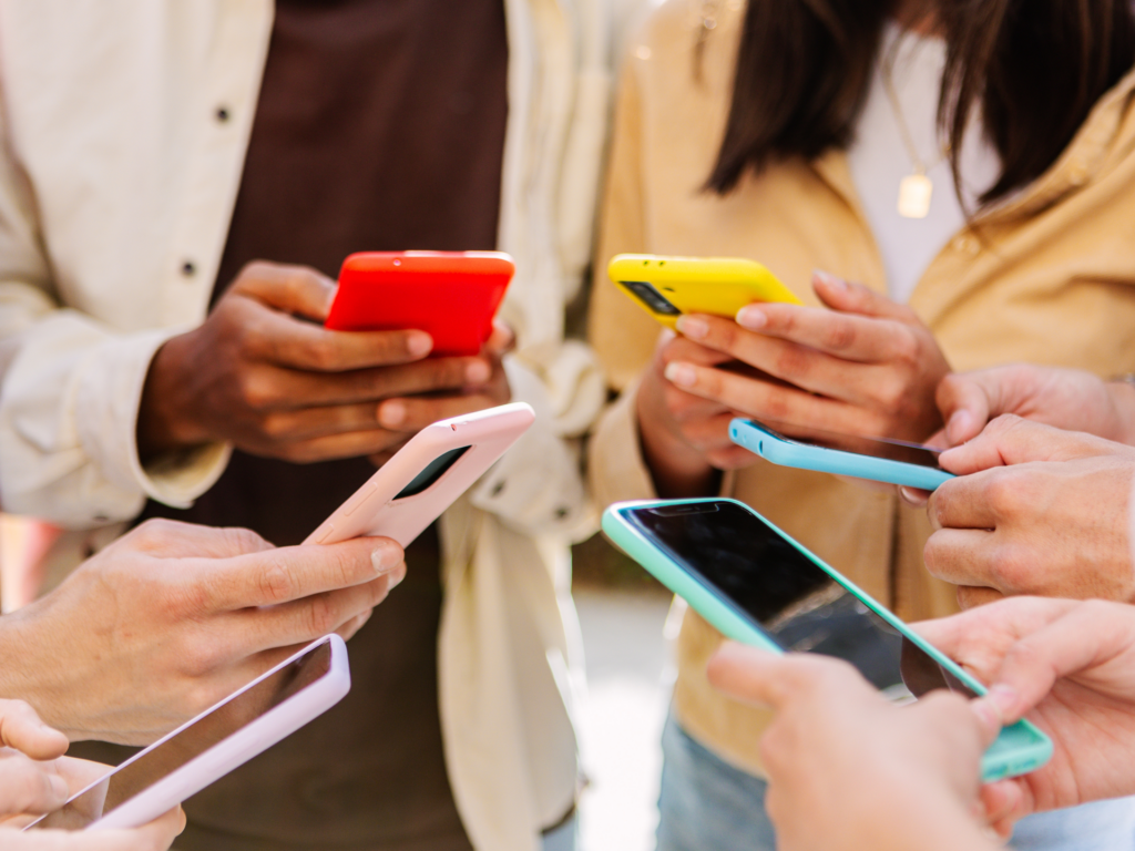 Group of teens looking satisfied with their phones
