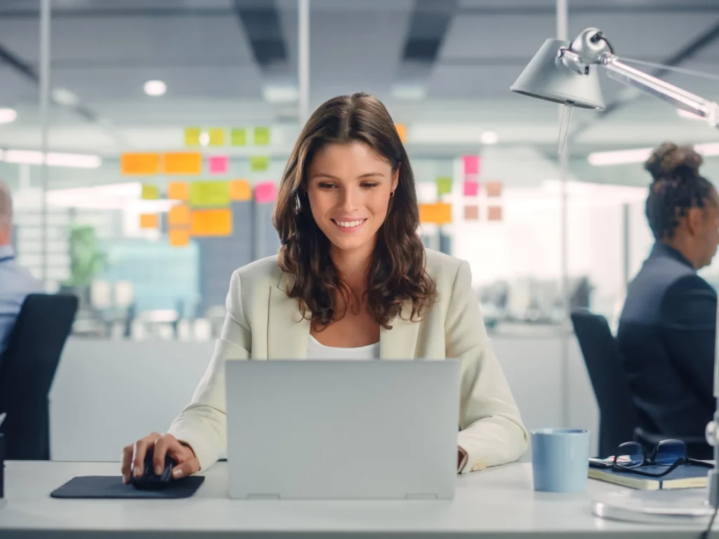Young Businesswoman looking satisfied and happy at a laptop